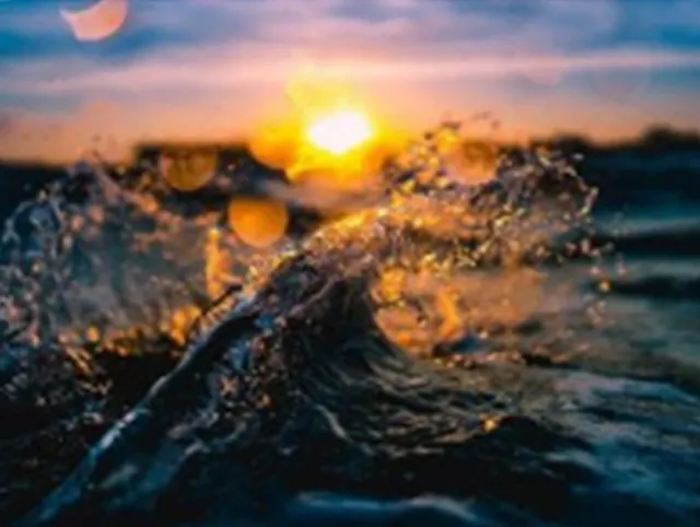 Sonnenuntergang über Meereswellen, Lichtreflexion auf Wasser.